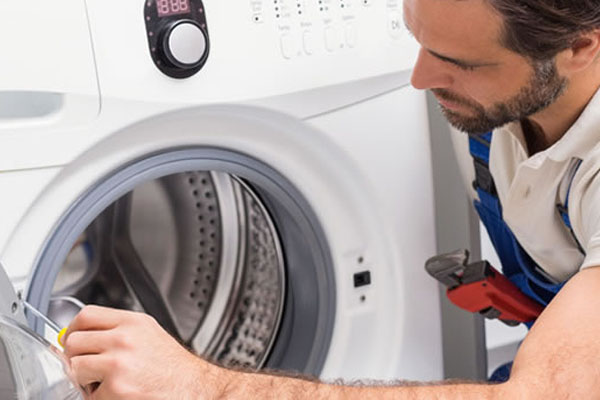 An appliance repair technician repairing a washing machine