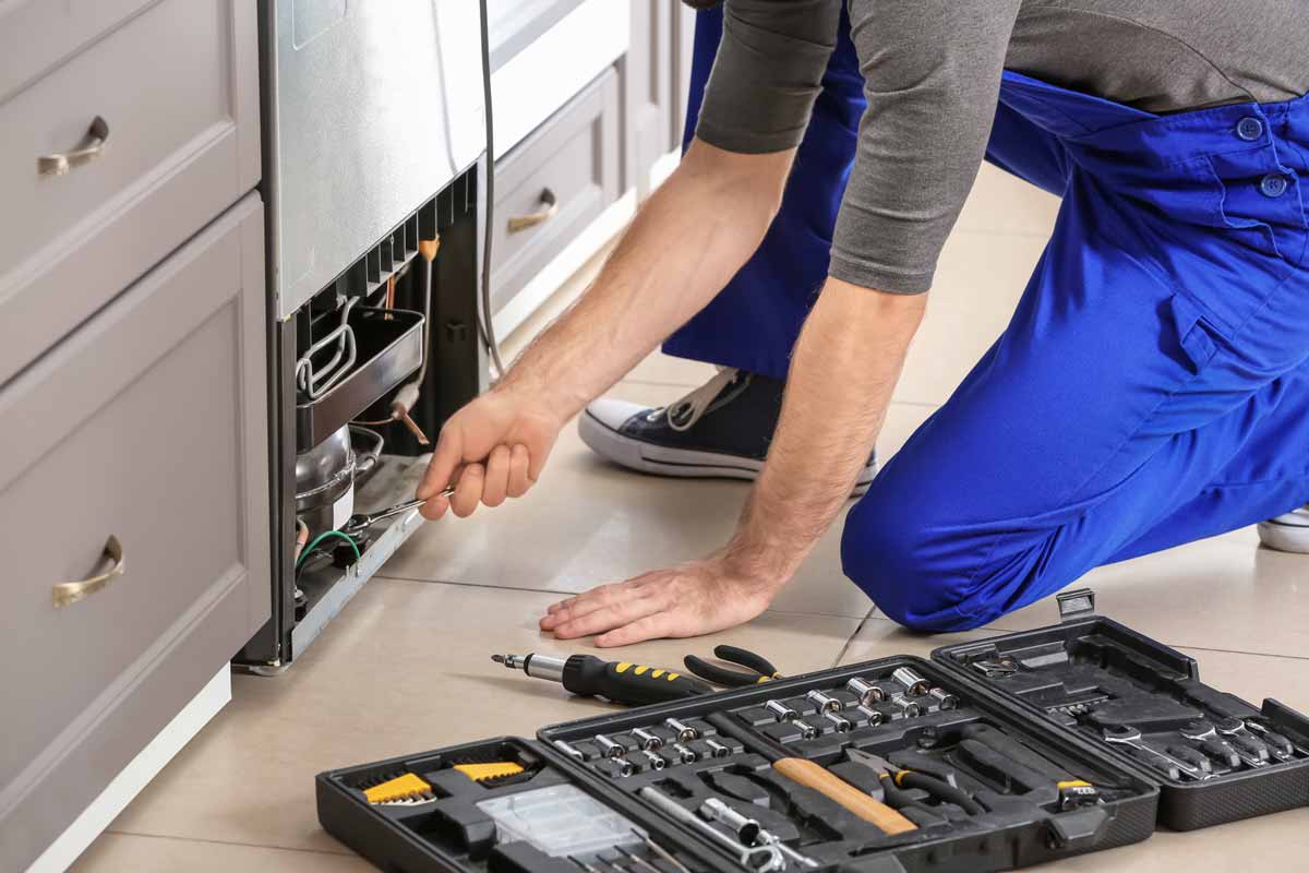 A technician repairing a refrigerator